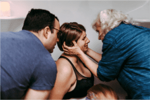 husband and doula supporting mother
