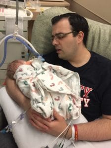 father holding his infant son and singing to Edison