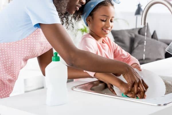 mom teaching daughter to do household chores