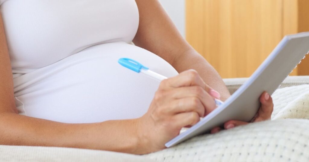 mom making a list for postpartum tips for new moms